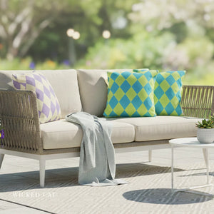 Outdoor sofa with patterned cushions and a blanket on a patio