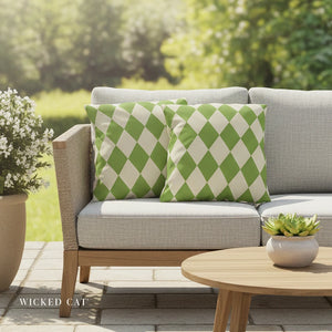 Outdoor patio with gray sofa, green and white checkered pillows, and a small table with plants.