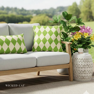 Outdoor sofa with green and white checkered pillows, a small table with flowers, and 'Wicked Cat' branding.