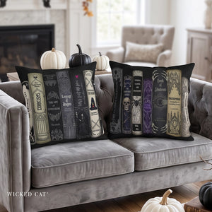 Two decorative throw pillows with gothic book spine designs are displayed on a gray tufted sofa in a living room setting. The left pillow features cream and gray book spines, and the right pillow features black, purple, and beige book spines with skulls and occult illustrations.