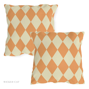 Two orange and beige checkered pillows on a white background