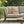 Gray outdoor sofa with orange and white patterned cushions on a patio, featuring 'Wicked Cat' branding.