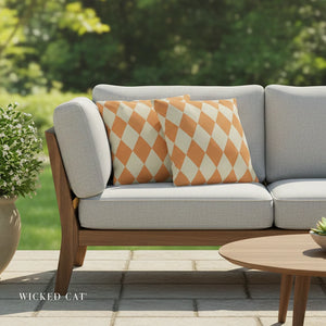 Gray outdoor sofa with orange and white patterned cushions on a patio, featuring 'Wicked Cat' branding.