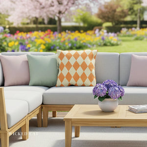 Outdoor patio set with a couch, coffee table, and decorative pillows in a garden setting.