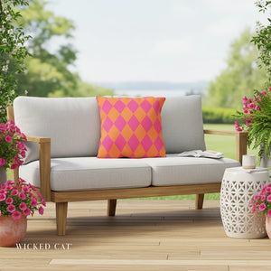 Outdoor sofa with a colorful pillow on a wooden deck, surrounded by potted plants.