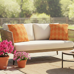 Outdoor patio with a beige sofa with orange pillows, potted plants, and a small table.