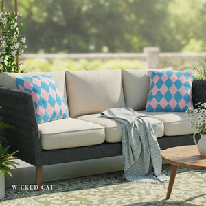 Outdoor sofa with patterned cushions and a blanket, set against a blurred green outdoor background.