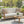 Outdoor patio set with a sofa, coffee table, and decorative pillows on a sunny day.