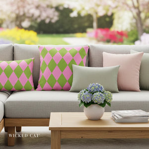 Gray sofa with colorful pillows and a wooden coffee table with flowers and books in an outdoor setting.