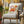 Decorative pillow with pumpkin and autumn leaves on a chair outdoors.