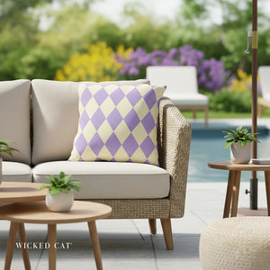 Outdoor patio setting with a beige sofa, patterned pillow, and small table with plants.