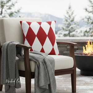 Chair with a red and white patterned pillow and gray blanket on a patio with a fire pit and mountain view.