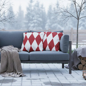 Gray outdoor sofa with red and white patterned cushions on a patio with trees in the background