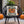 Decorative pillow with Halloween design on a black wicker chair outdoors.