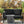 Black outdoor sofa with snake-patterned cushions on a patio with Halloween decorations.