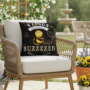 Chair with a pillow featuring 'Stings Brewing Co. Buzzzzed' design outdoors.