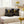 Two decorative pillows with bee designs and text on a beige couch in a living room setting.