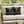 Two black pillows with bee designs on a white outdoor sofa.