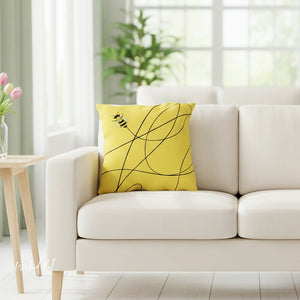 Yellow pillow with black design on a beige sofa in a bright living room.