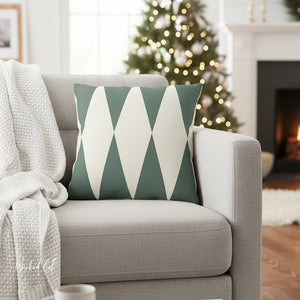 Gray sofa with a green and white geometric pillow, Christmas tree in the background