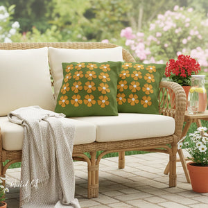 Wicker outdoor furniture set with floral cushions and a blanket on a patio.