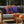 Outdoor seating area with Halloween-themed pillows and a pumpkin on a wooden table.