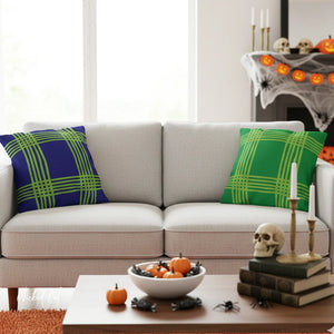 Living room with a couch featuring blue and green plaid pillows, Halloween decorations on a coffee table.