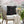 Decorative pillow with pink hearts on a chair in an outdoor setting with cherry blossoms.