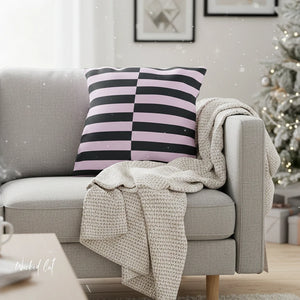 Gray sofa with a striped pillow and beige blanket, Christmas tree in the background