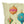 A square decorative throw pillow featuring a whimsical illustration of colorful hanging ornaments on a pale cream background with small gold polka dots.