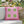 Pink pillow with green squares on a chair outdoors