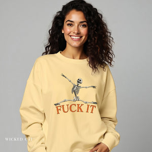Woman wearing a yellow sweatshirt with a skeleton design and text, against a gray background.