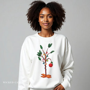Woman wearing a white sweatshirt with a Christmas tree design on a gray background