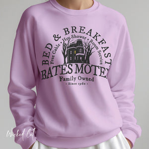 Purple sweatshirt with 'Bates Motel' design on a plain background