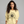 Woman wearing a yellow sweatshirt with 'Bates Motel' design on a gray background