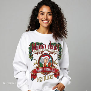 Woman wearing a white sweatshirt with a Christmas-themed design featuring Santa Claus and 'Moonshine Distillery'.
