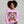 Person wearing a pink sweatshirt with a 'Mama Claus' design on a gray background