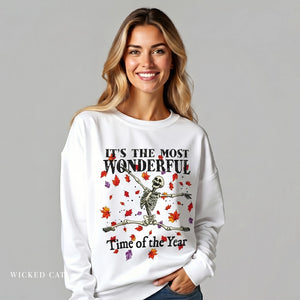 Woman wearing a white sweatshirt with a skeleton design and text on a gray background