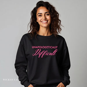 woman wearing black sweatshirt with pink embroidered text 'unapologetically difficult'