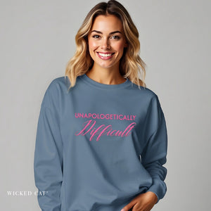 woman wearing blue sweatshirt with embroidered pink text 'unapologetically difficult'