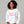 woman wearing white sweatshirt with embroidered pink text 'unapologetically difficult'