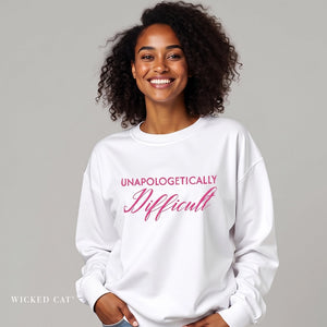 woman wearing white sweatshirt with embroidered pink text 'unapologetically difficult'
