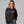 Blond woman wearing a black sweatshirt with 'ew, people' embroidered on the front.