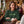 Woman in a green sweatshirt with 'ew, people' embroidered on the front sitting in a Christmas coffee shop