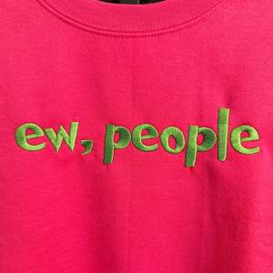 close up of pink sweatshirt with 'ew, people' embroidered text.