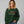 Woman wearing a green sweatshirt that reads Festivus tis the season to air your grievances.