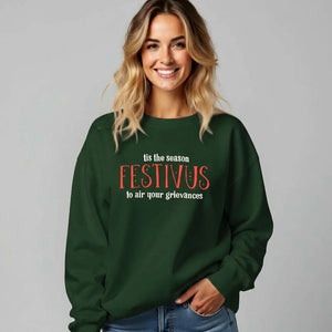 Woman wearing a green sweatshirt that reads Festivus tis the season to air your grievances.