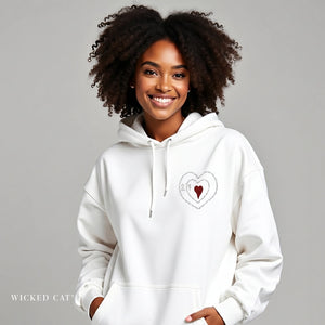 Woman wearing a white hoodie with a heart design on a gray background