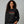 Woman wearing black sweatshirt that reads ho ho ho'n around town in red and green text.