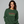  Woman wearing a green sweatshirt that reads ho ho ho'n around town in red and green text.